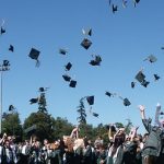 Students at a graduation throwing their caps in the air