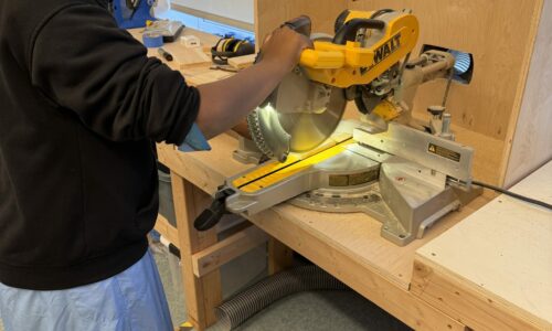 A student using a saw in Pre-Engineering